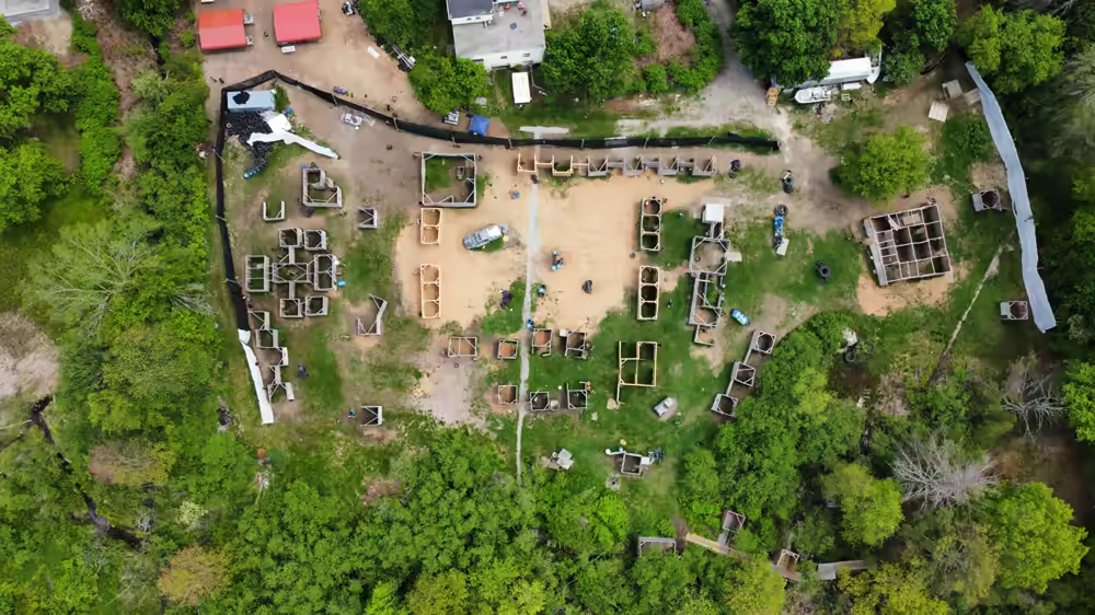 Drone aerial overview of an active airsoft match showing the full arena layout