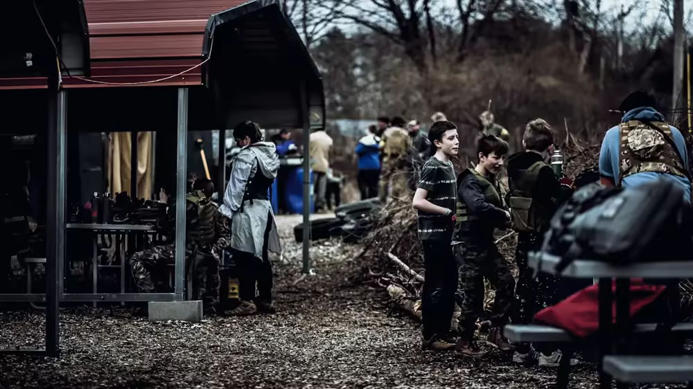 Airsoft and paintball players preparing for a match, gearing up and socializing